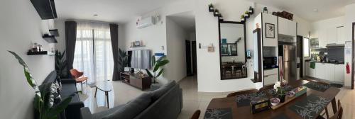 a living room with a couch and a table at Desaru Dhancell Executive Homestay Netflix,8Pax,Wifi in Desaru