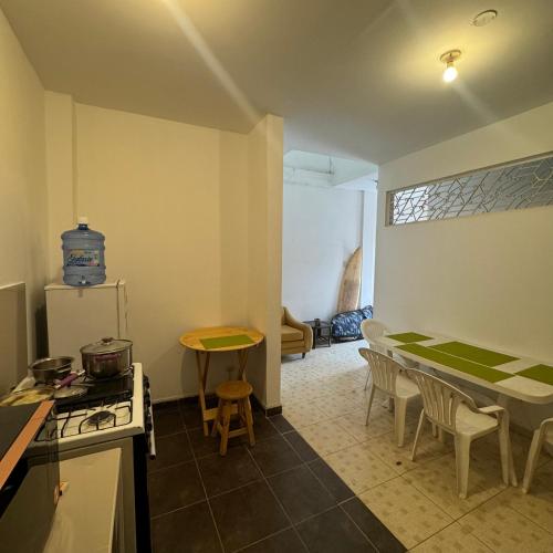 a kitchen with a stove and a table with chairs at La Arteza Pacasmayo in Pacasmayo