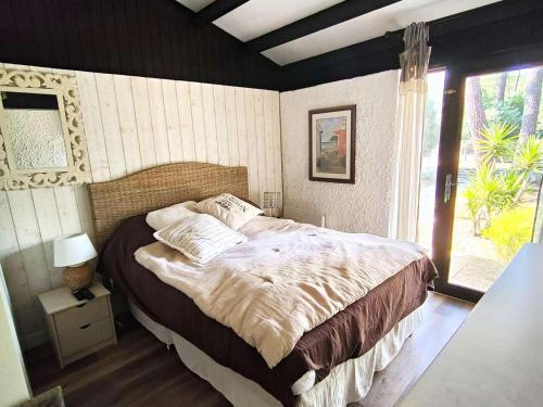 une chambre avec un grand lit et une fenêtre dans l'établissement Villa rénovée avec jardin, terrasse, clim et WiFi à Lège-Cap-Ferret - FR-1-736-43, à Lège-Cap-Ferret