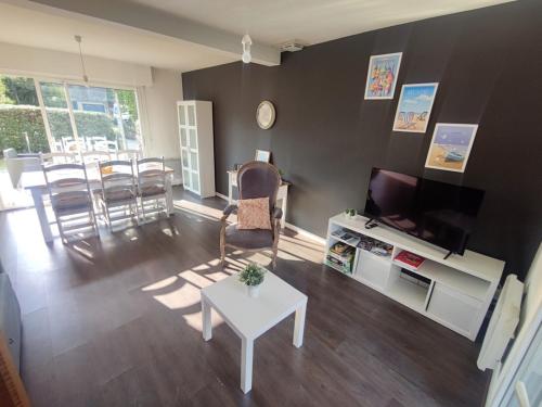 un salon avec une télévision, une table et des chaises dans l'établissement Maison Sarzeau 6 pers - Entre plage et commerces, animaux admis - FR-1-639-127, à Sarzeau