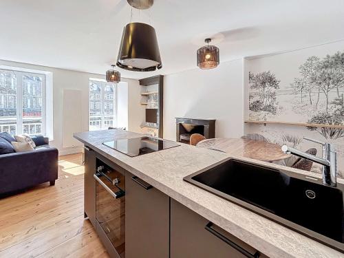 une cuisine avec un évier et un salon dans l'établissement Maison cosy cœur de ville, 200m plage, 2 chambres - FR-1-361-556, à Saint-Pair-sur-Mer