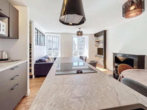 Il comprend une cuisine et un salon avec un grand comptoir en marbre. dans l'établissement Maison cosy cœur de ville, 200m plage, 2 chambres - FR-1-361-556, à Saint-Pair-sur-Mer