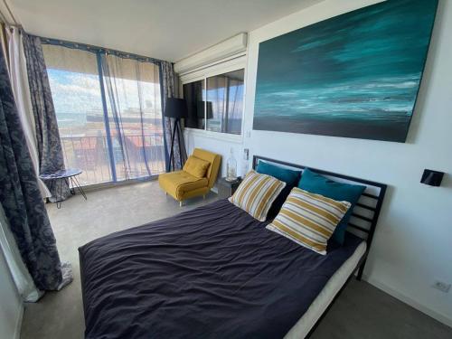 une chambre avec un lit, une chaise et des fenêtres dans l'établissement T3 Confort avec Clim et Wifi, Terrasse, 300m Commerces, Plage à Proximité, Parking Privé - FR-1-81-623, au Barcarès