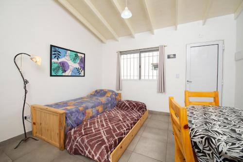 un dormitorio con una cama y un sofá en Saucegrandezuna, en Balneario Sauce Grande