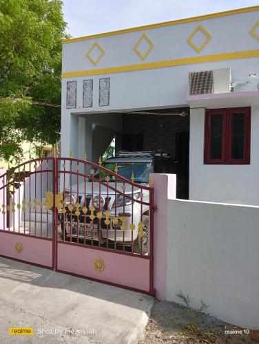 a pink fence in front of a house at JAS HOMESTAY Madurai in Samayanallūr