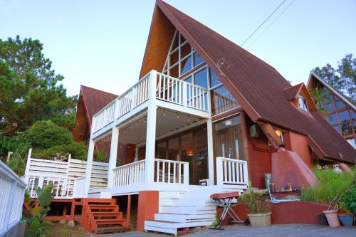 a house with a large white and brown roof at NEW OPEN!Popular beaches are within a 5minute walk in Inbu