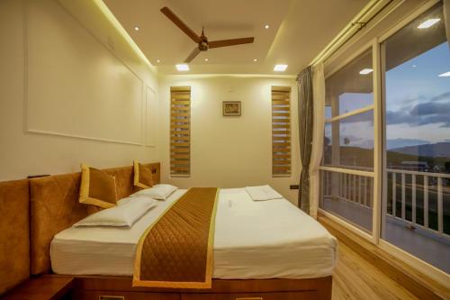 a bedroom with a bed and a large window at The Haven by Xplore Indo in Ooty