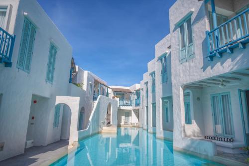 an alley with white buildings and a swimming pool at Resort de Paskani in Hua Hin