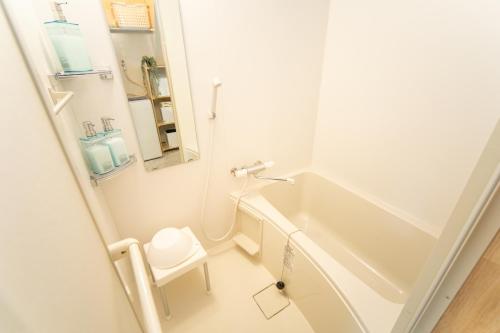 a small bathroom with a tub and a toilet at Yokkaichi Kawaramachi Hotel in Hazu