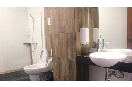 a bathroom with a toilet and a sink at My Studio Hotel Losari Makassar in Makassar
