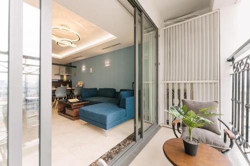 a living room with a blue couch and a table at D’Leroi Soleil - Westlake Suite & Apartment in Hanoi