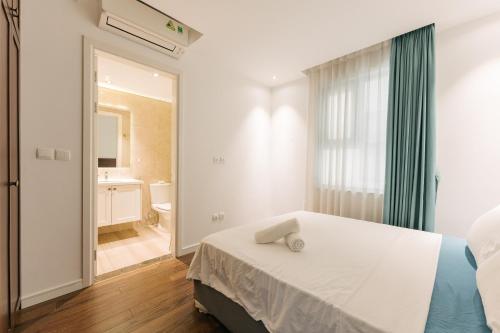 a bedroom with a bed and a bathroom at D’Leroi Soleil - Westlake Suite & Apartment in Hanoi