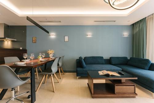 a living room with a blue couch and a table at D’Leroi Soleil - Westlake Suite & Apartment in Hanoi