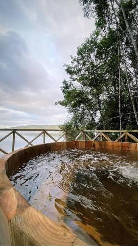 a large tub filled with water next to a bridge at Refugio Mayapehue, Lago Natri Chiloé in El Púlpito
