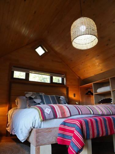 a bedroom with a bed in a wooden ceiling at Refugio Mayapehue, Lago Natri Chiloé in El Púlpito