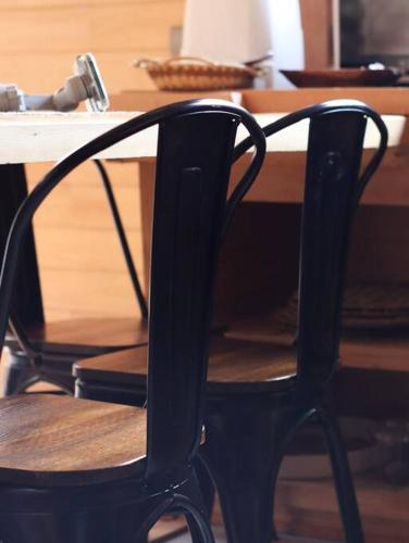 a black chair sitting in front of a wooden table at Refugio Mayapehue, Lago Natri Chiloé in El Púlpito