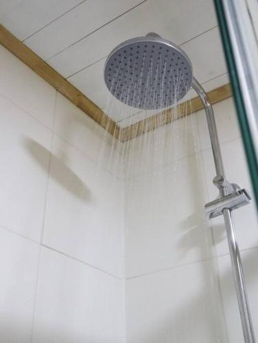 a shower with a shower head with water at Refugio Mayapehue, Lago Natri Chiloé in El Púlpito