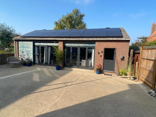 a house with solar panels on top of it at Coastguards boathouse in Wells next the Sea