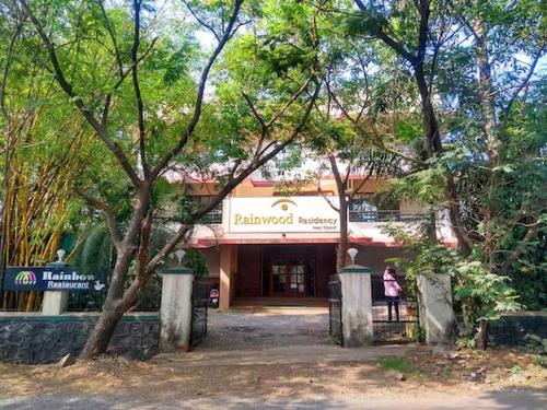 a woman standing in front of a building at Rainwood Residency in Lonavala