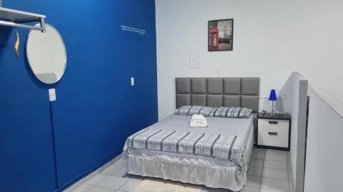 a blue room with a bed and a mirror at Flat completo - ótima . localização -Centro in Mogi das Cruzes