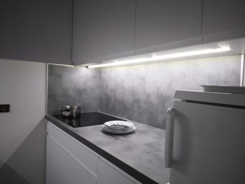 Il comprend une cuisine équipée d'un comptoir avec des plaques de cuisson et d'un réfrigérateur. dans l'établissement Résidence Carroley B - Studio pour 4 Personnes 08, à Mâcot La Plagne