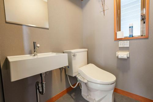 a bathroom with a white toilet and a sink at プライベートリゾート星垂 in Atami