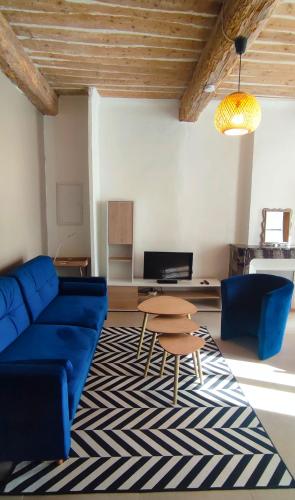 a living room with a blue couch and a table at Appartement provençal avec balcon dans le Var in Les Arcs sur Argens