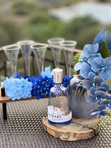 a bottle of vinegar sitting on a table with blue flowers at La Casa del Vagabondo in Belvedere