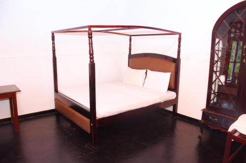 a bedroom with a canopy bed with white sheets and pillows at Ranpokuna Bungalow with 3 Bed Rooms in Kiriella