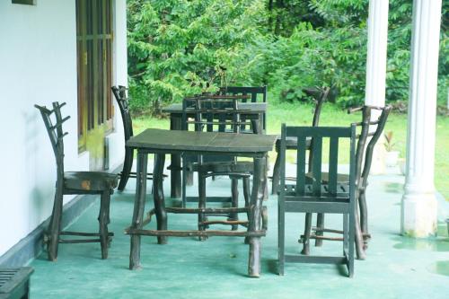a wooden table and chairs sitting on a porch at Ranpokuna Bungalow with 3 Bed Rooms in Kiriella