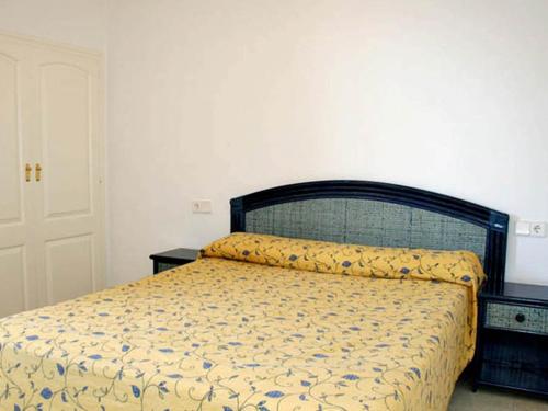 a bedroom with a bed with a yellow and blue bedspread at Apartamentos Zafiro Unitursa in Calpe