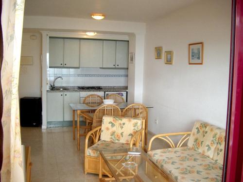 sala de estar con mesa y sillas y cocina en Apartamentos Zafiro Unitursa, en Calpe