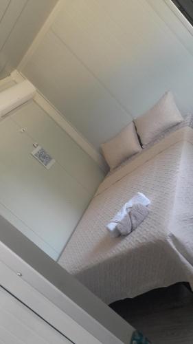 a small bedroom with a bed with white sheets and pillows at Apartamentos Equipados DMR #3 in Uvita
