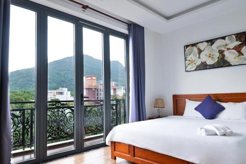 a bedroom with a bed and a large window at Kim Ngân Hotel in Con Dao