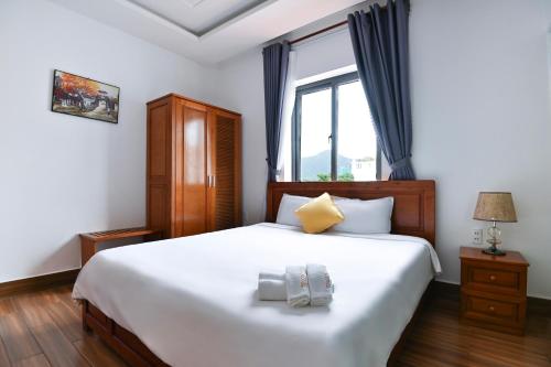 a bedroom with a large white bed and a window at Kim Ngân Hotel in Con Dao