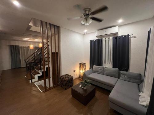a living room with a couch and a staircase at House of Ellisse in Lipa