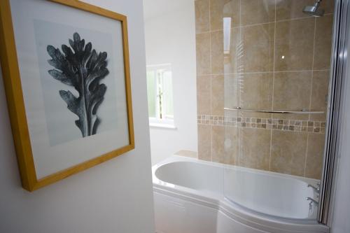 a bathroom with a bath tub and a picture at The Old Rectory Bed and Breakfast in Ruthin