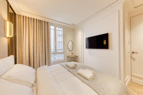 une chambre avec un grand lit blanc avec une fenêtre dans l'établissement Prestige l 3CH l 2SDB l Clim l Louvre, à Paris