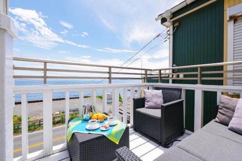 a patio with two chairs and a table on a balcony at Oceanfront Villa Hale Kahakai - Vacation STAY 52109v in Miura