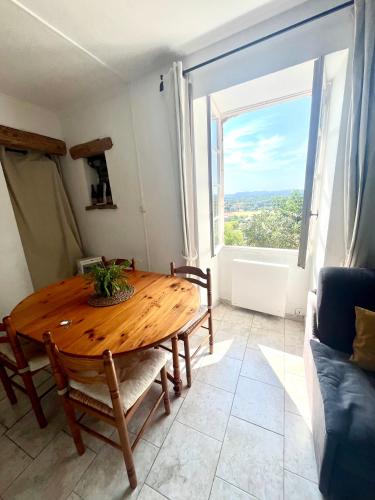 une salle à manger avec une table en bois et une grande fenêtre dans l'établissement Maison du Vigneron, à Vézénobres