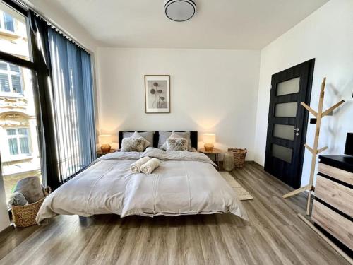 a bedroom with a large bed and a large window at Apartmán Masaryk Square in Děčín