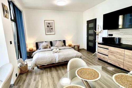 a bedroom with a large bed and a table at Apartmán Masaryk Square in Děčín