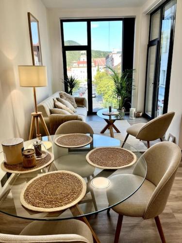 a living room with a glass table and chairs at Apartmán Masaryk Square in Děčín