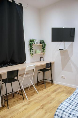 a desk in a room with two chairs and a tv at Studio Bethel in Liège