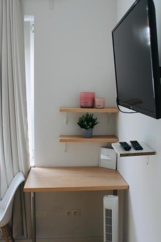 a desk with a television on a wall at Studio Bethel in Liège
