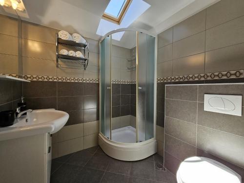 a bathroom with a shower and a sink and a toilet at Apartments Andrea in Malinska