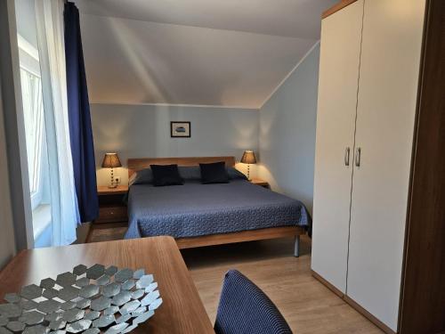 a small bedroom with a bed and a table at Apartments Andrea in Malinska