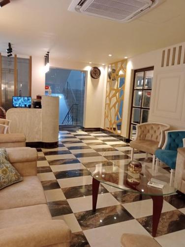 a living room with a glass table and chairs at The Tayef Residency in Chittagong