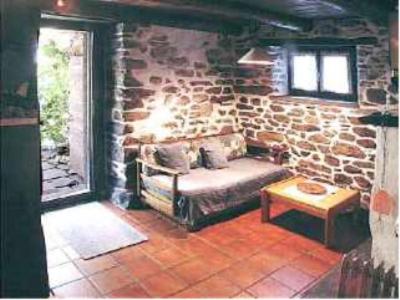 ein Wohnzimmer mit einem Sofa und einer Steinmauer in der Unterkunft Rustico Il Nido in Maggia