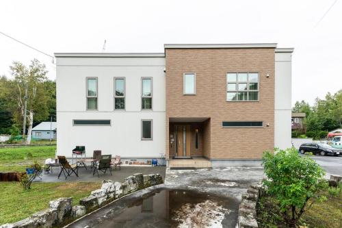 a house with a pond in front of it at The Casa Azucena in Sapporo